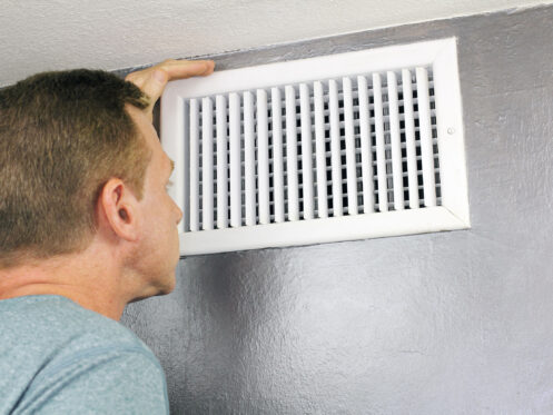 Man checking an air vent