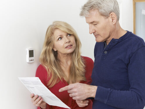 Concerned homeowners reviewing an energy bill
