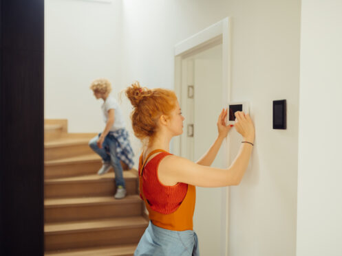 Woman adjusting a thermostat